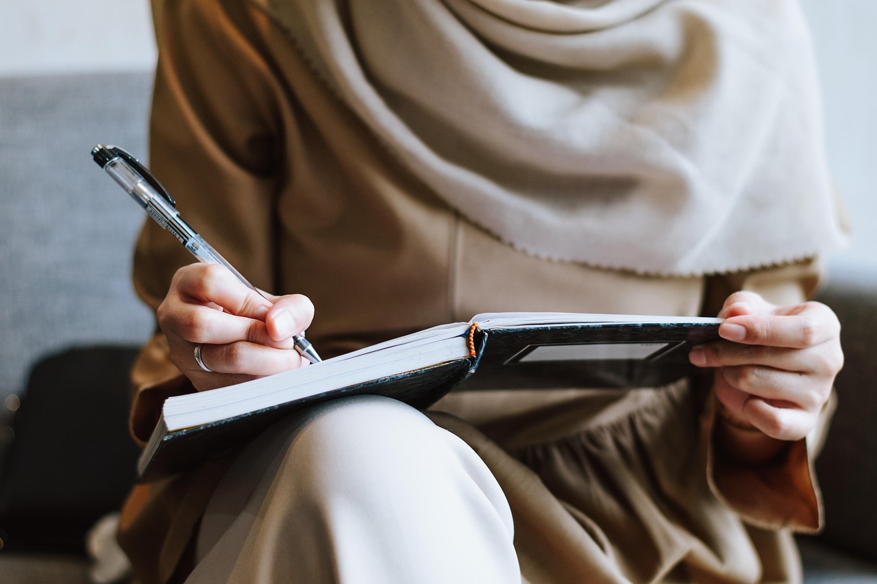 Muslim, woman, writing — Protect Your Platform Using Real-Time Identity Verification