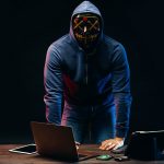 anonymous hacker man isolated over dark space