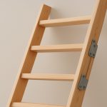 A wooden loft ladder leaning against a wall, showcasing a simple and functional design.